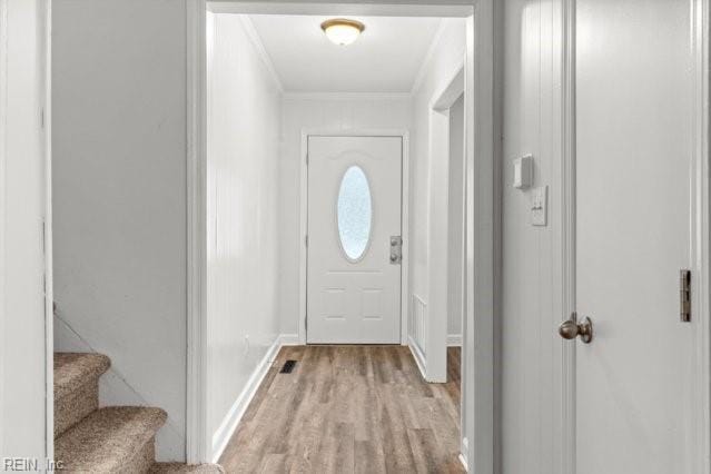 doorway to outside featuring stairs, ornamental molding, baseboards, and light wood-style floors