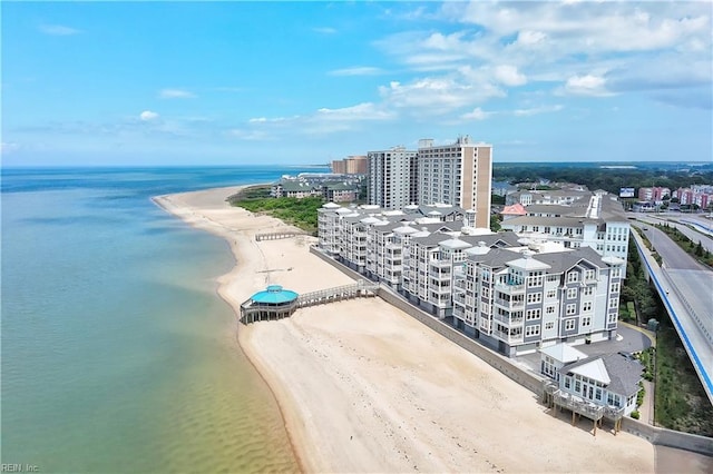 birds eye view of property featuring a water view, a beach view, and a city view