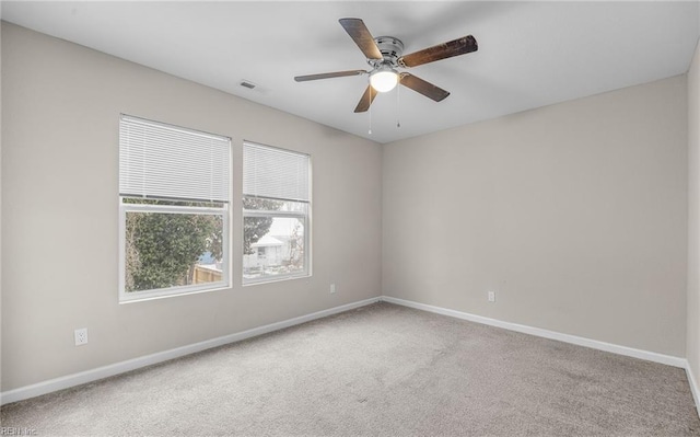 empty room featuring a ceiling fan, carpet, visible vents, and baseboards