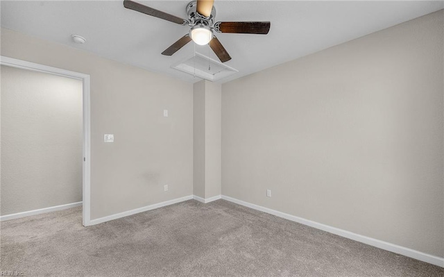 empty room featuring light carpet, attic access, and baseboards