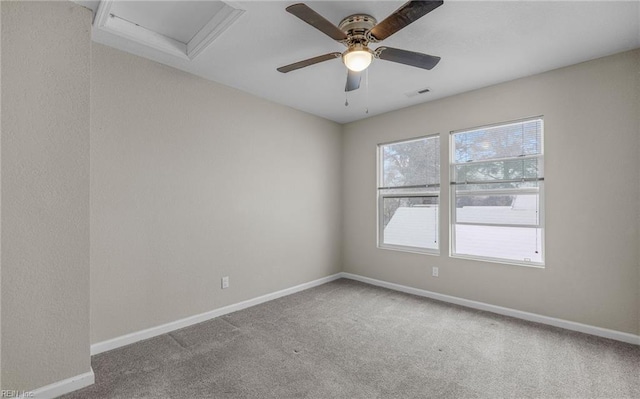 carpeted empty room featuring baseboards, visible vents, ceiling fan, and attic access