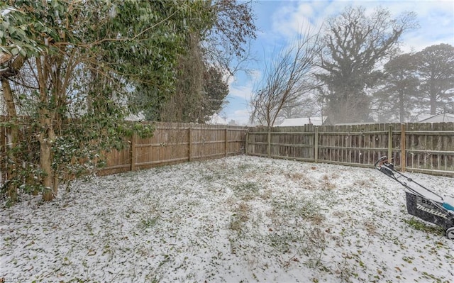 yard layered in snow featuring a fenced backyard