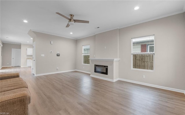 unfurnished living room with recessed lighting, a ceiling fan, baseboards, light wood-style floors, and a glass covered fireplace