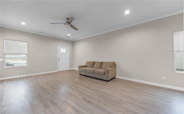 unfurnished room featuring light wood-style floors, baseboards, and crown molding