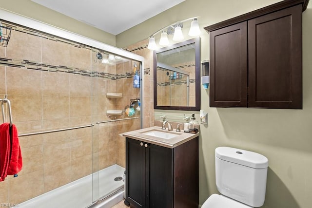 full bathroom with toilet, a shower stall, and vanity