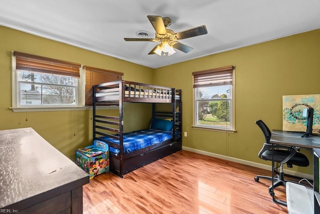 bedroom featuring light wood finished floors, baseboards, and a ceiling fan