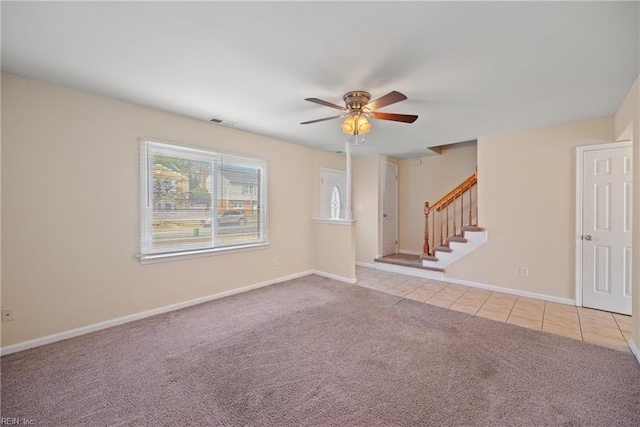 unfurnished room featuring light tile patterned flooring, light carpet, visible vents, baseboards, and stairway