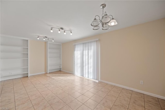 empty room featuring baseboards, built in features, a chandelier, and light tile patterned flooring