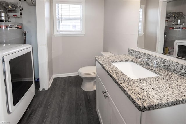 bathroom featuring gas water heater, toilet, wood finished floors, baseboards, and washer / clothes dryer