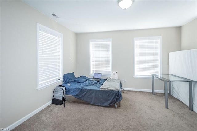 carpeted bedroom with visible vents and baseboards