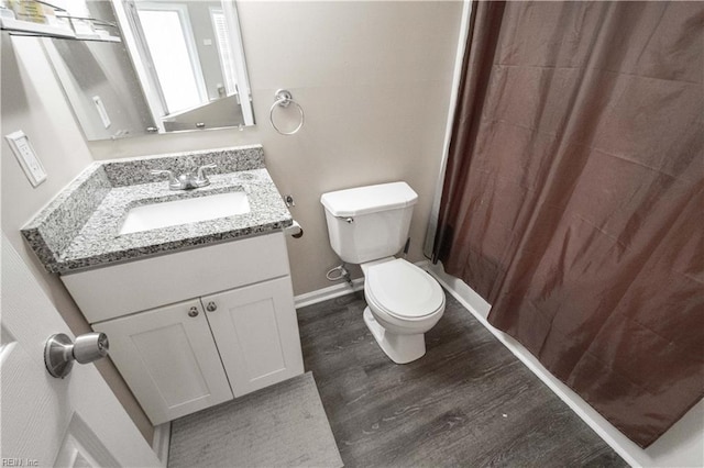 full bathroom with toilet, vanity, wood finished floors, a shower with curtain, and baseboards