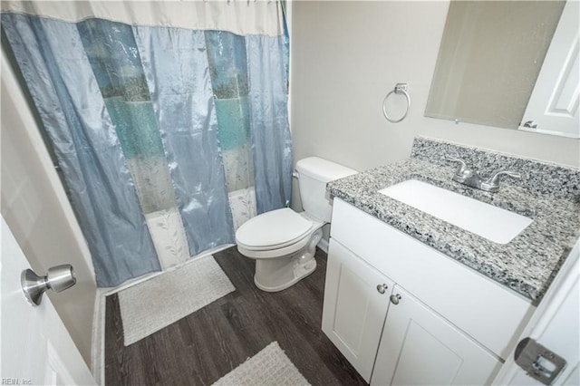 bathroom with curtained shower, vanity, toilet, and wood finished floors