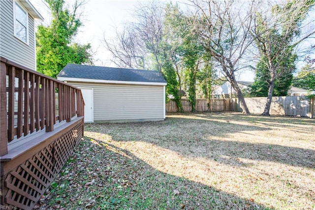 view of yard featuring fence, a wooden deck, and an outdoor structure