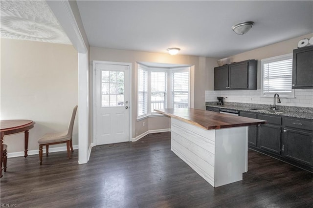 kitchen with dark wood-style floors, decorative backsplash, wooden counters, and a sink