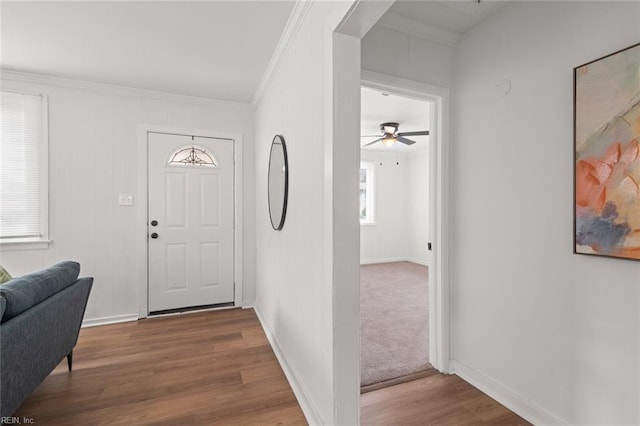 entrance foyer featuring ornamental molding, wood finished floors, and baseboards