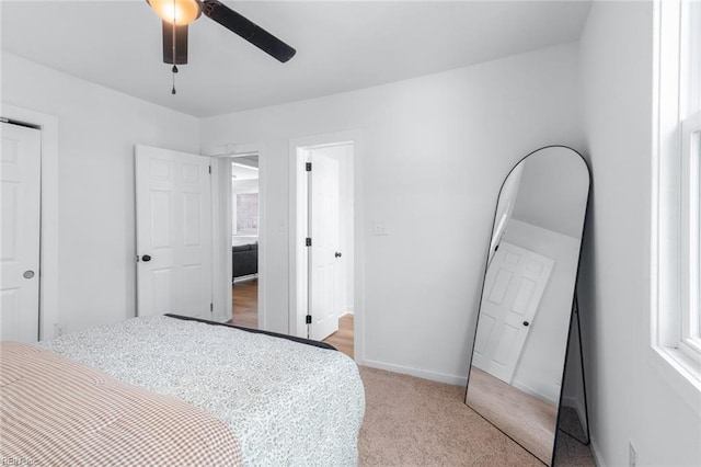 bedroom with baseboards, ceiling fan, and light colored carpet