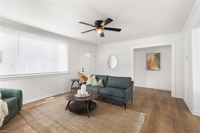 living room with visible vents, wood finished floors, a ceiling fan, and baseboards