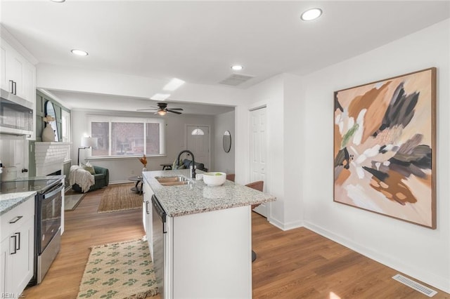 kitchen with electric range, visible vents, white cabinets, dishwasher, and a sink