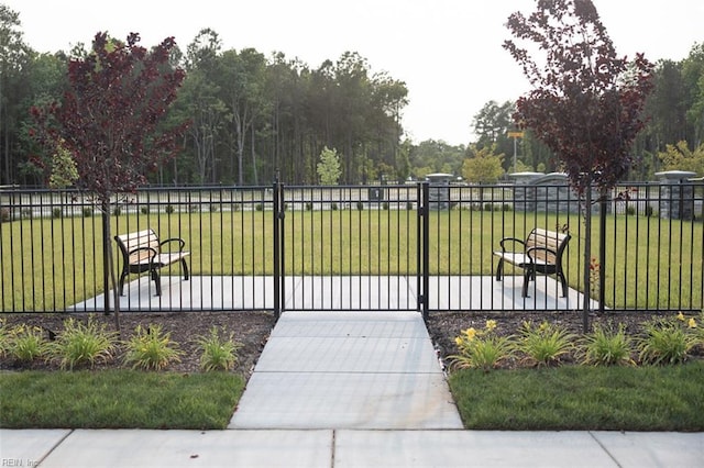 view of home's community with a gate, fence, and a yard