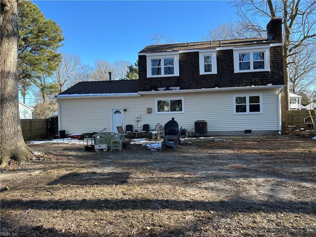 back of house featuring a shingled roof, a chimney, cooling unit, and fence