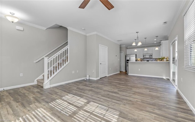 unfurnished living room with stairway, wood finished floors, and crown molding