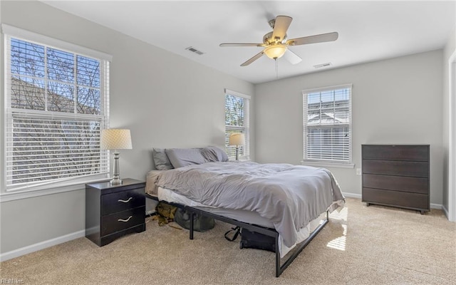 bedroom featuring ceiling fan, light colored carpet, visible vents, and baseboards