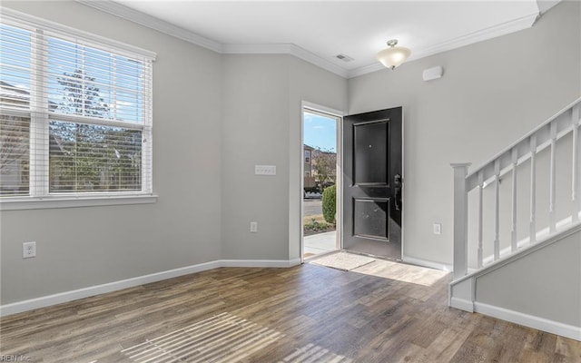 foyer entrance with plenty of natural light, stairs, crown molding, and wood finished floors