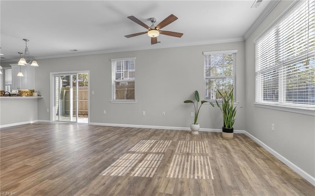 spare room featuring baseboards, wood finished floors, a ceiling fan, and crown molding