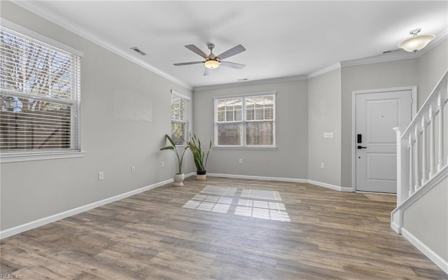 foyer with stairs, crown molding, and wood finished floors