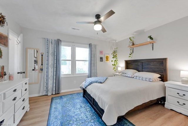 bedroom with a ceiling fan, visible vents, light wood-style flooring, and baseboards