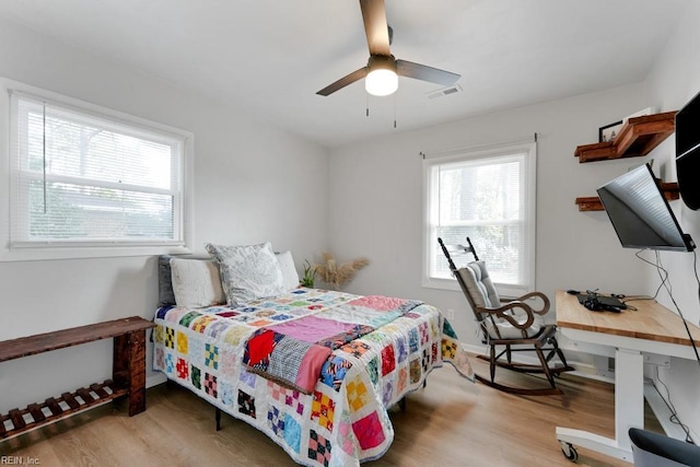 bedroom with visible vents, ceiling fan, light wood-style flooring, and baseboards