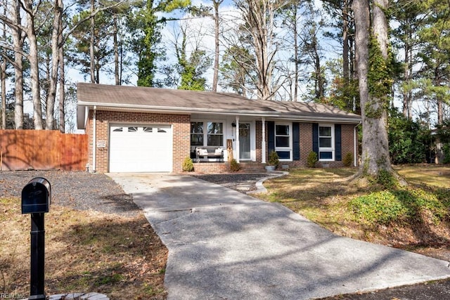 single story home with a garage, fence, concrete driveway, and brick siding