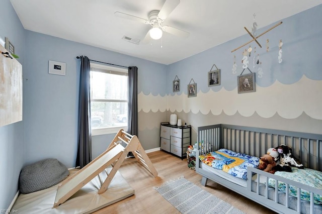 bedroom featuring ceiling fan, wood finished floors, visible vents, and baseboards