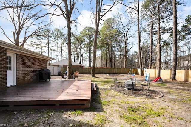 view of yard with an outdoor fire pit, a fenced backyard, and a wooden deck