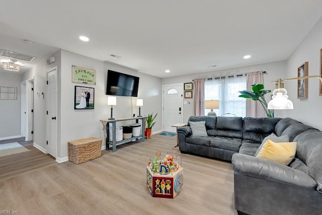 living area featuring light wood-type flooring, baseboards, and recessed lighting