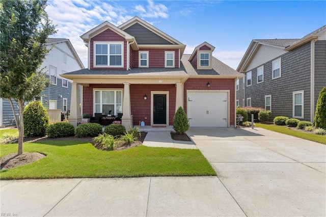 craftsman house featuring a garage, concrete driveway, a front lawn, and a porch