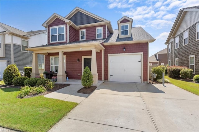 craftsman-style home featuring a porch, a front yard, concrete driveway, and a garage