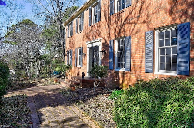 view of side of home featuring a patio area and brick siding