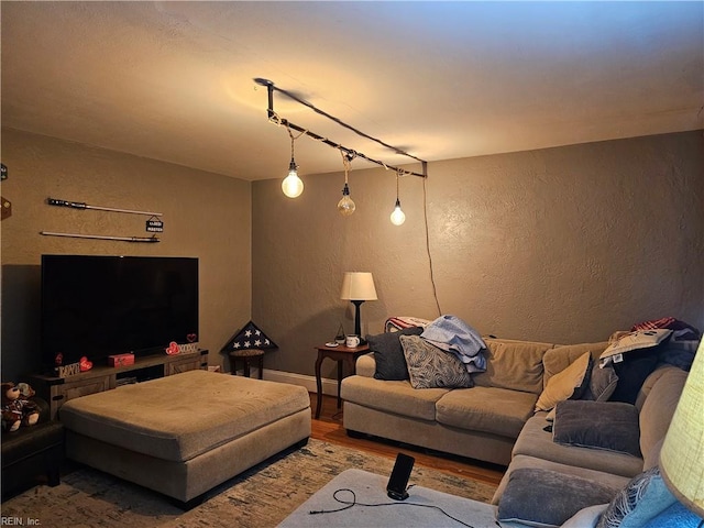 living room featuring wood finished floors and a textured wall