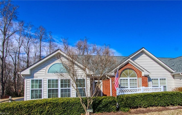 ranch-style home featuring brick siding and a shingled roof