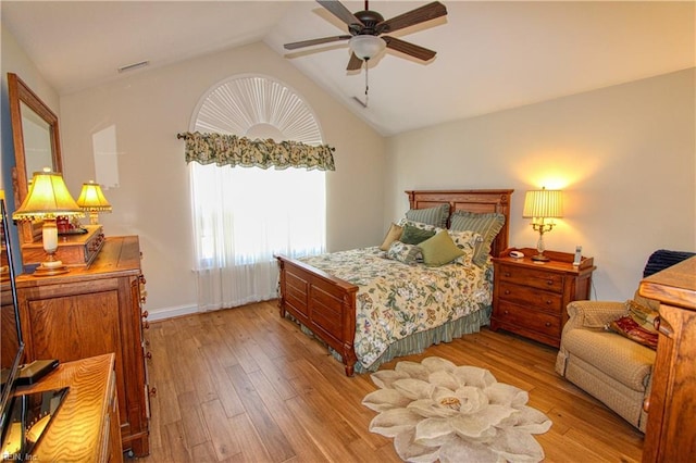 bedroom with lofted ceiling, ceiling fan, visible vents, and wood finished floors