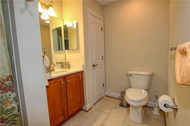 bathroom featuring tile patterned flooring, baseboards, vanity, and toilet