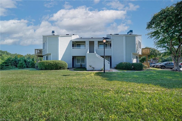 view of front of property featuring a balcony and a front yard