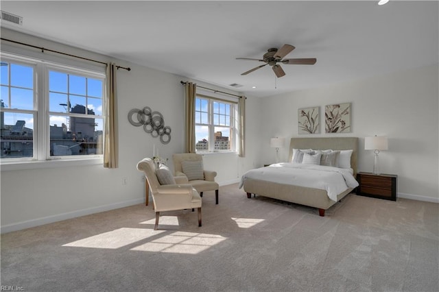 bedroom featuring baseboards, ceiling fan, visible vents, and light colored carpet