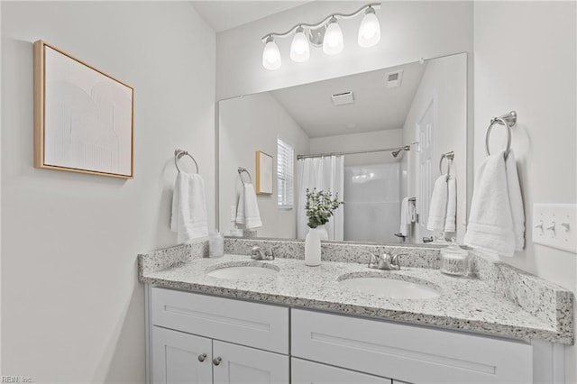 full bath with double vanity, curtained shower, visible vents, and a sink