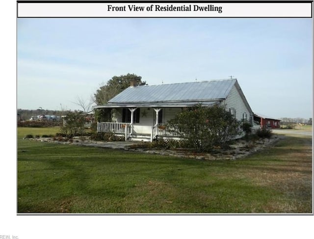 farmhouse featuring a porch, metal roof, and a front lawn