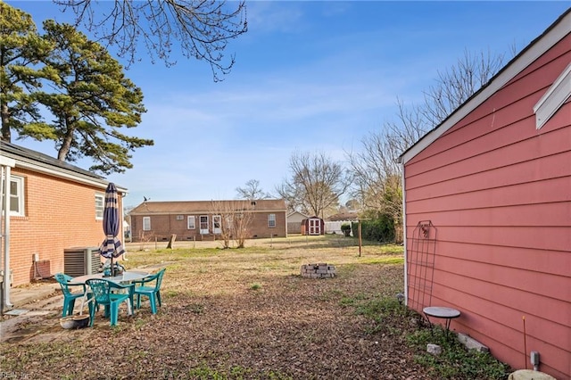 view of yard featuring an outdoor fire pit and central AC