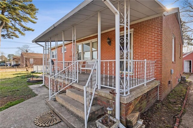 exterior space featuring covered porch and brick siding