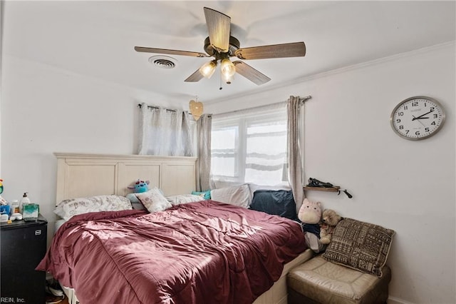 bedroom with ornamental molding, visible vents, and a ceiling fan