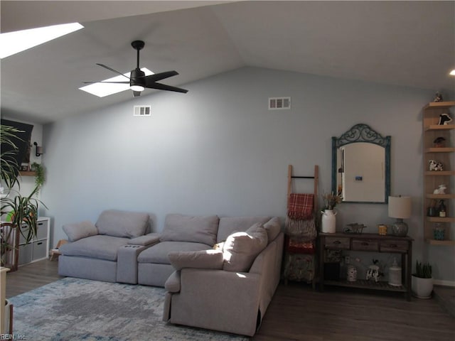 living room with ceiling fan, dark wood-type flooring, lofted ceiling with skylight, and visible vents